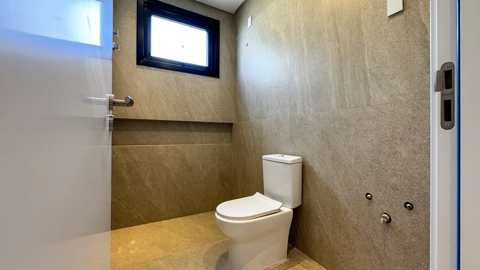 Lavabo revestido em porcelanato Portobello com iluminação natural